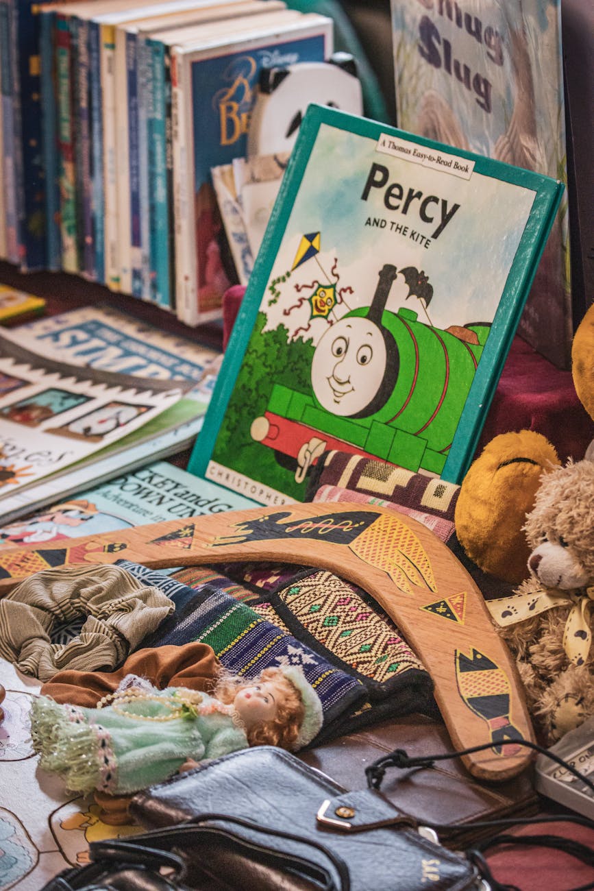 A diverse array of collectibles spread out on a table - trading cards, vintage toys, coins, and comic books