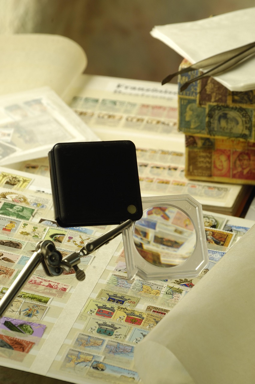Close-up of a collector using a magnifying glass to examine stamps and collectibles