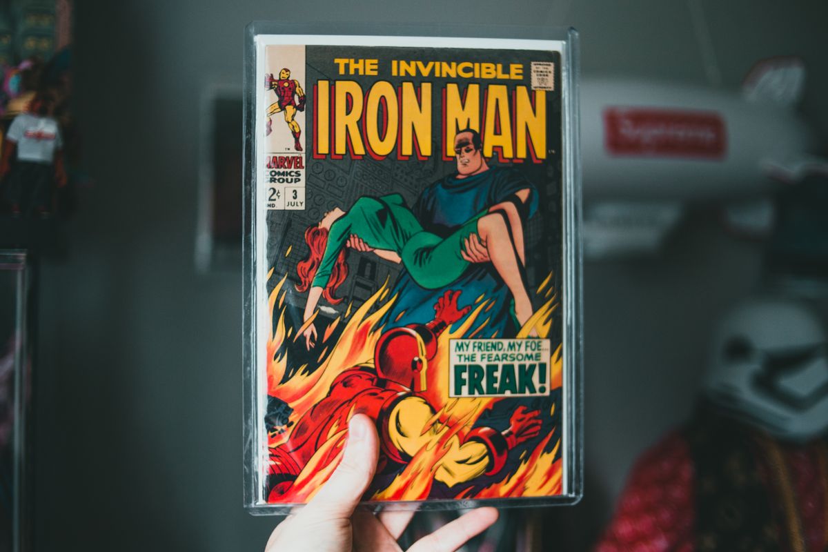 Vintage Iron Man comic book held by hand, showcasing superhero imagery
