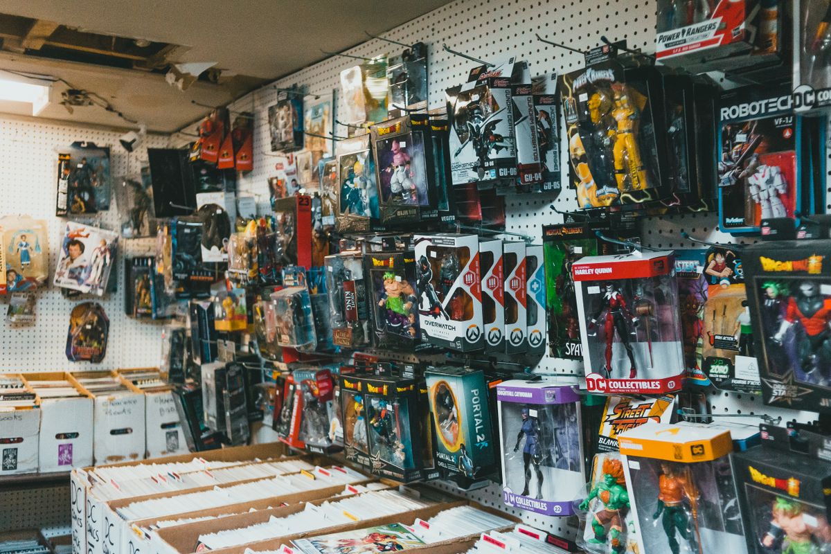 Assorted toy collectible packages with robots and superhero figures hanging on display rack