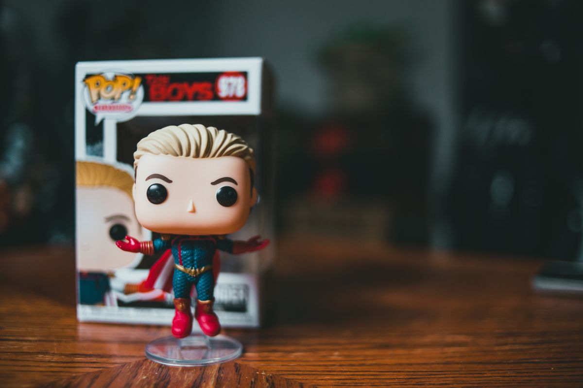 Small bright vinyl figure toy character placed on wooden table surface
