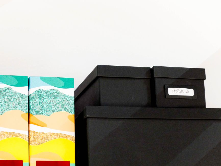 Stack of colorful storage boxes on a shelf