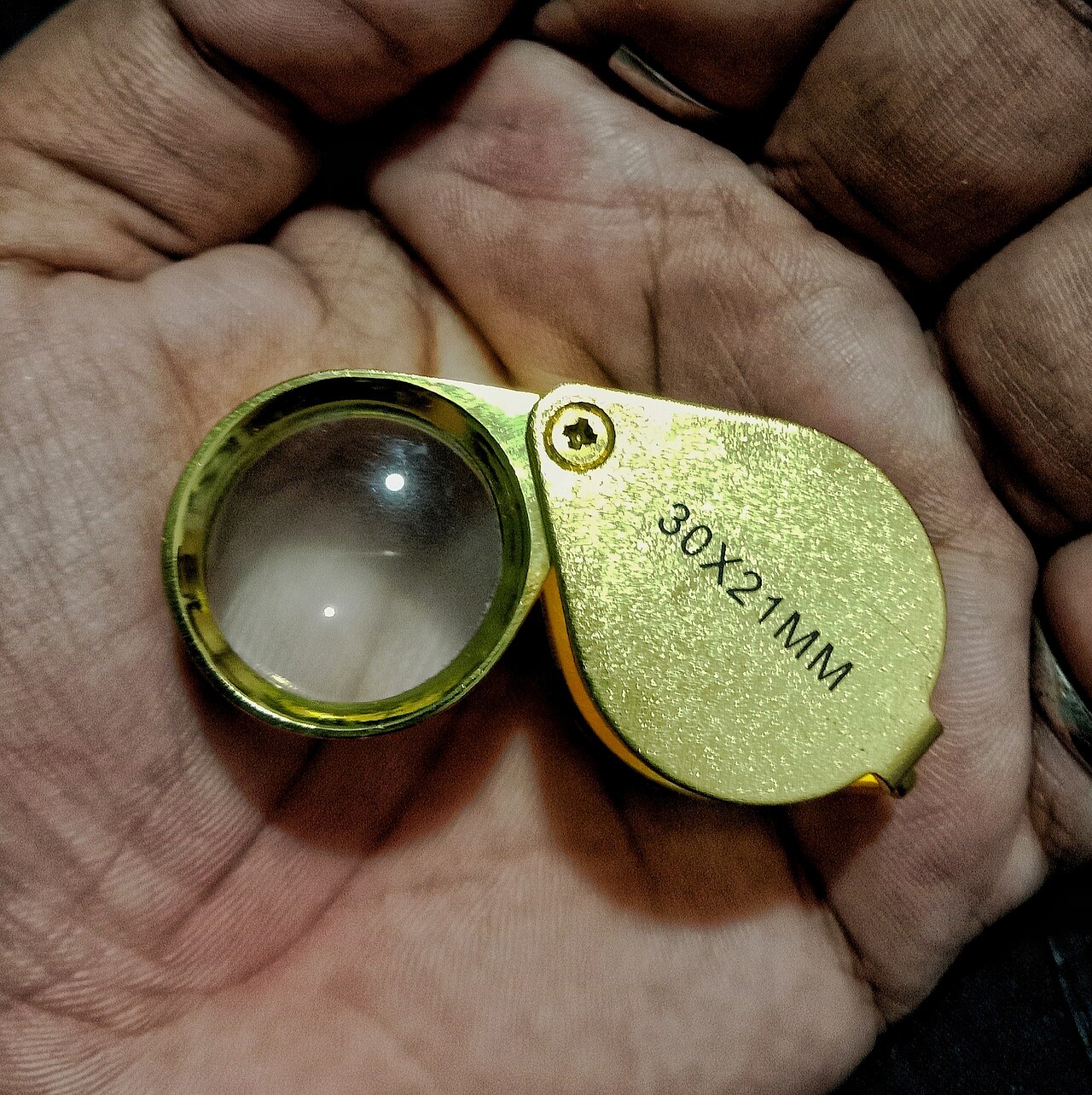 A stainless steel jeweler's loupe for coin inspection