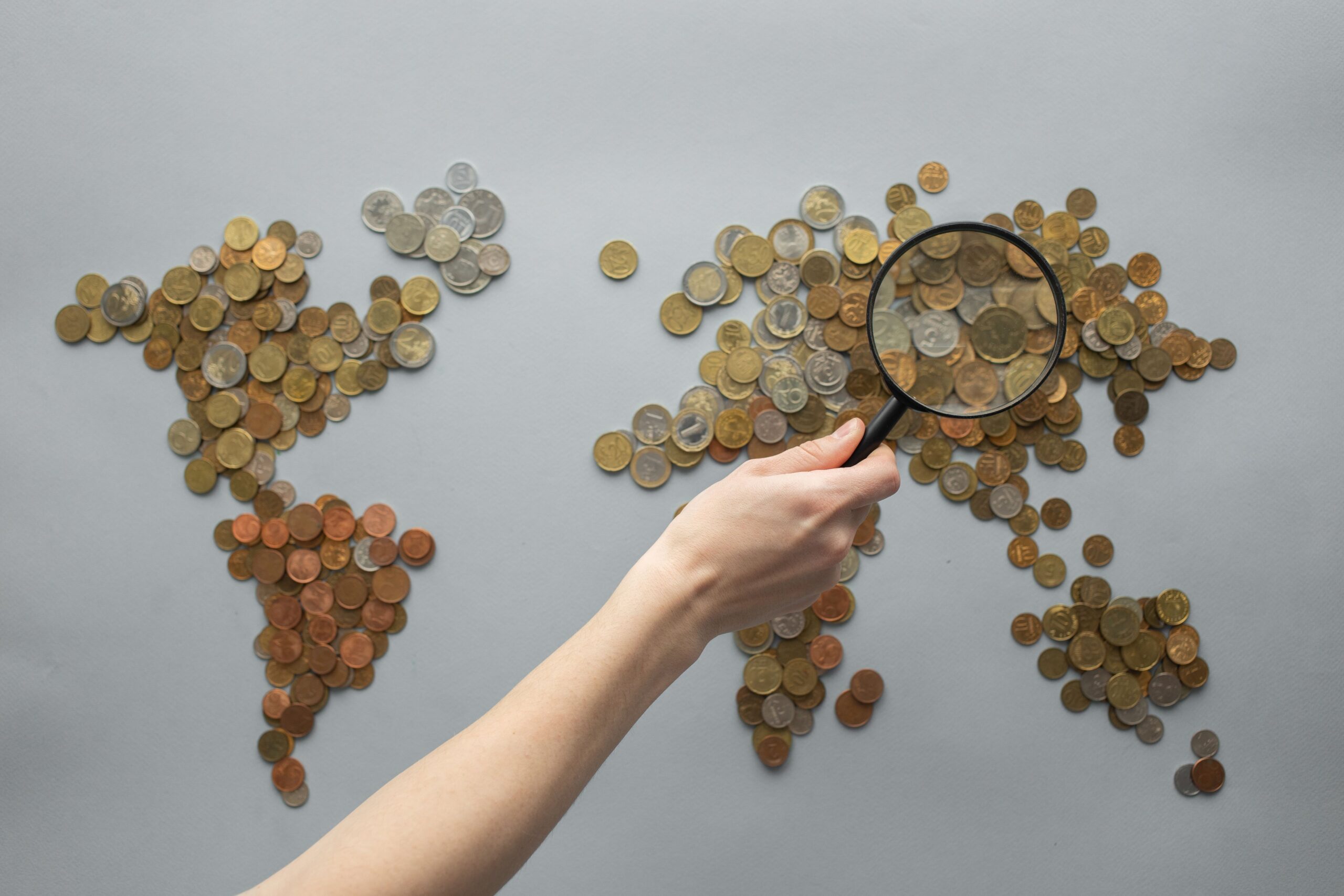 Magnifying glass over coins for identifying coin mint marks