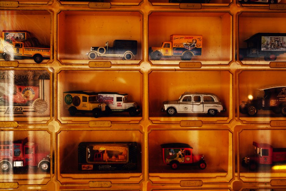 Vintage die-cast model cars displayed in a protective showcase