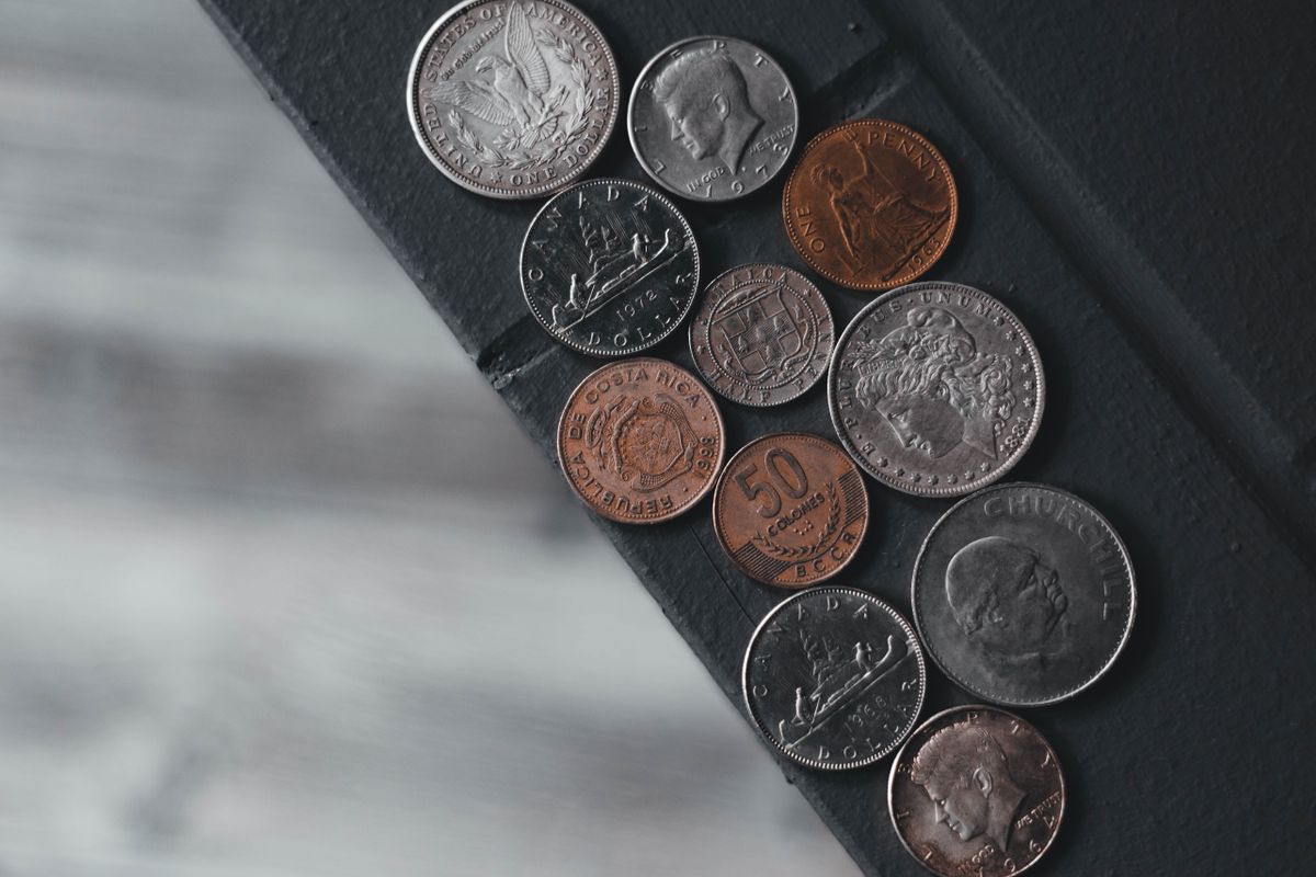 Coin Storage Mistakes That Cost You Grade Points — and How to Fix Them 1 Various international coins displayed on a textured surface, showing diversity in coin collecting