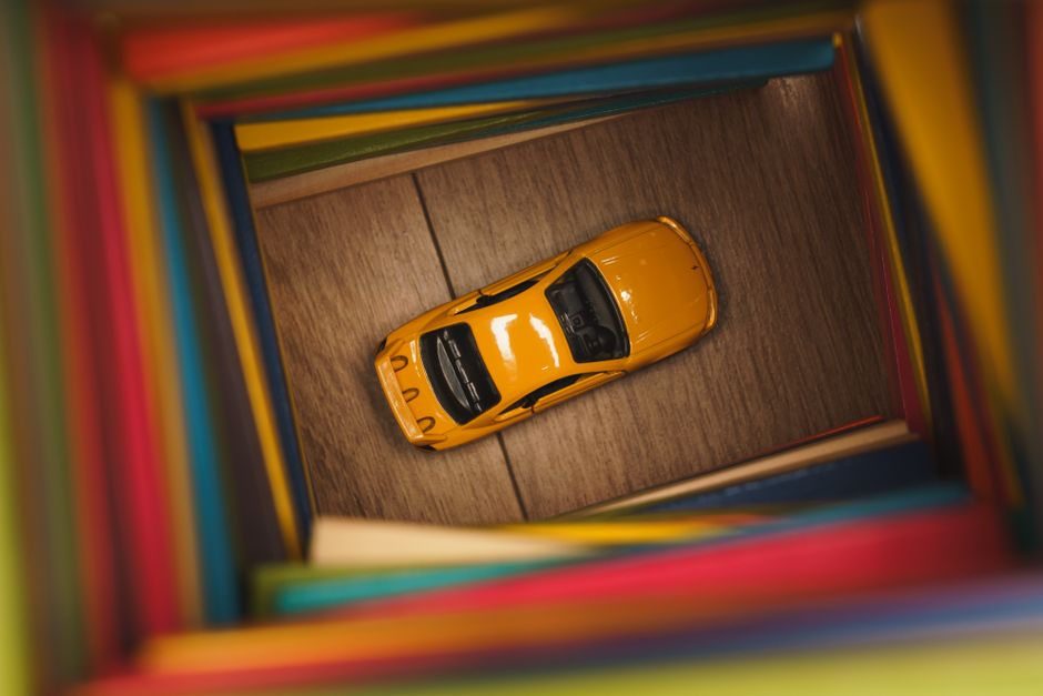 Yellow toy car in a colorful box displayed from above