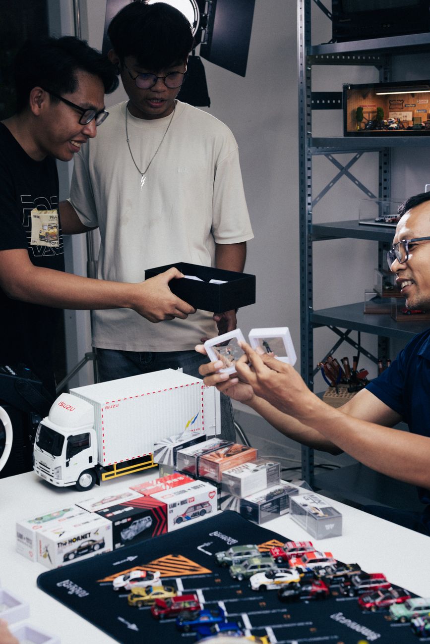 Collectors examining a diecast model car collection