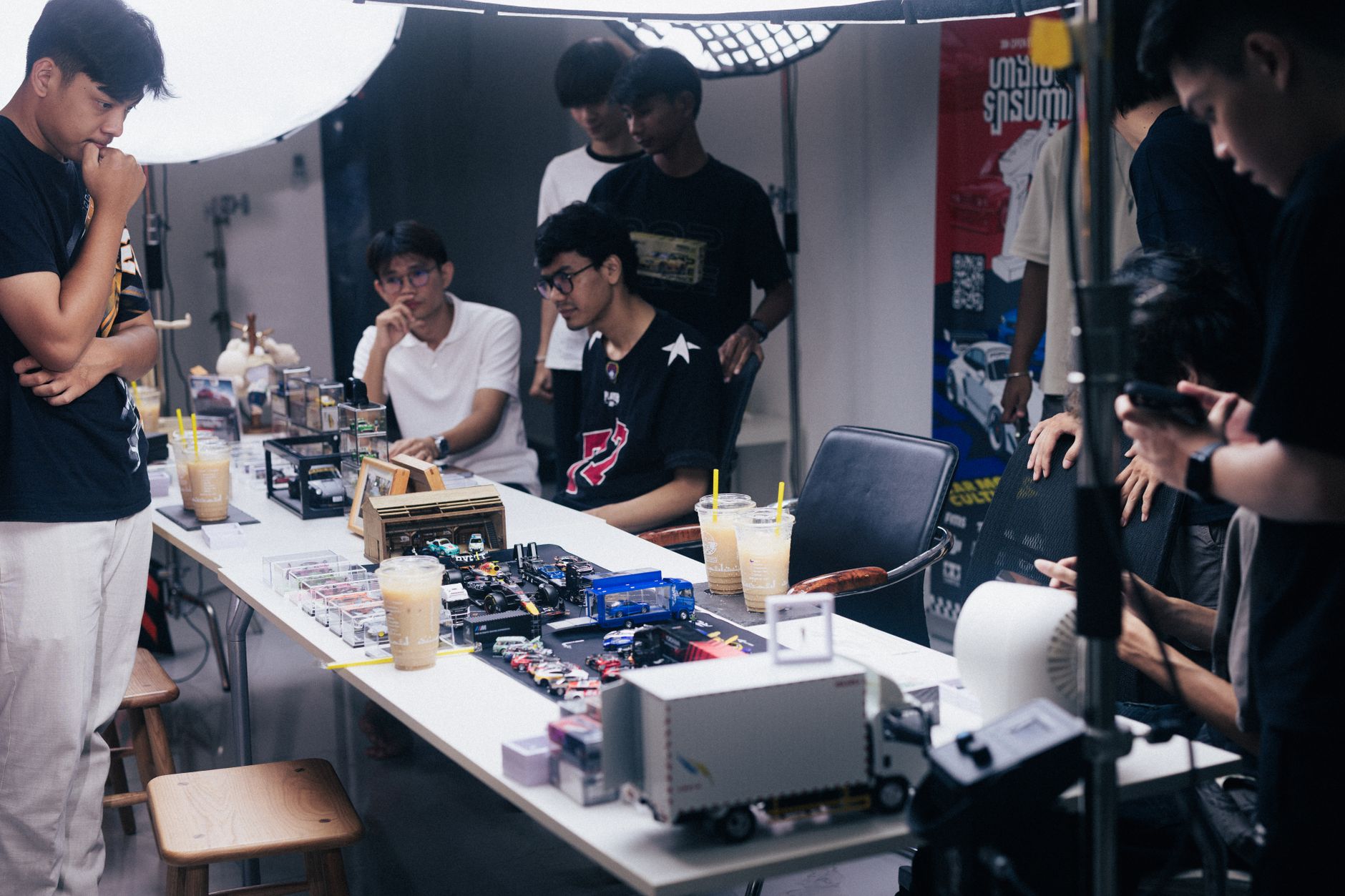 Collectors inspecting loose diecast cars on a table